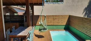 a porch with a hammock and a table and a pool at Casa Super Astral no Sul da Ilha in Florianópolis