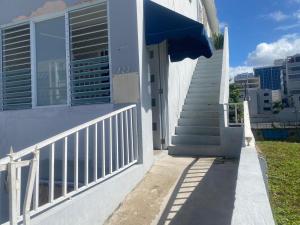 a staircase leading to a building with a blue awning at Apartment Close to Beach & Private Parking in San Juan +9 photos