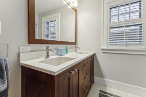 a bathroom with a sink and a mirror at Charming Ann Arbor Retreat Near DT & Attractions home in Ann Arbor