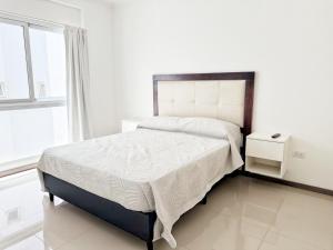 una camera da letto bianca con un letto grande e una finestra di VENETO V DEPARTAMENTOS a Villa Carlos Paz Altre 28 foto