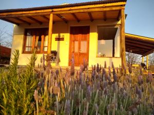 a yellow house with a field of purple flowers at Casa en Villa Yacanto hermosa vista in Villa Yacanto +4 photos
