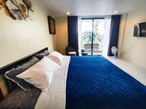 a bedroom with a large bed with a blue blanket at The Pixel Cape Panwa Beach Condo in Panwa Beach