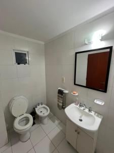 a white bathroom with a toilet and a sink at Altos Resistencia in Resistencia +15 photos