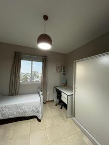 a bedroom with a bed and a desk and a window at Altos Resistencia in Resistencia