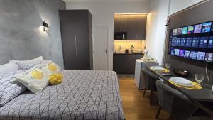Un dormitorio con una cama y una mesa y una cocina. en Loft Moderno e Aconchegante a Dois Passos da Feirinha do Alto!, en Teresópolis