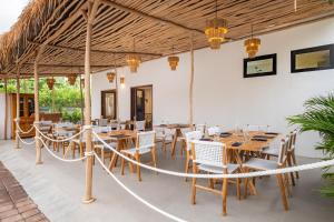 a restaurant with wooden tables and white chairs at Baliterraneo Boutique Resort in Seminyak