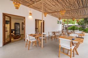 a dining room with wooden tables and chairs at Baliterraneo Boutique Resort in Seminyak