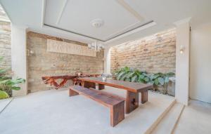 a room with a wooden bench and a brick wall at Villa Karen Homestay in Uluwatu