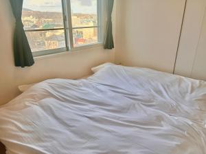 Llit o llits en una habitació de ホテル小樽キャナルビュー AMS東雲