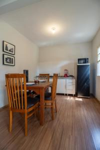 a kitchen with a table and chairs and a refrigerator at Garden 489 Studios Canasvieiras in Florianópolis