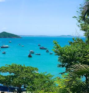 Une grande masse d'eau bleue avec des bateaux. dans l'établissement Flat Centro de Buzios, à Búzios