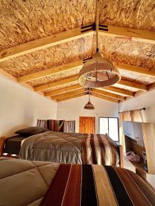 una camera con letto e soffitto con travi a vista di Cabañas San Pedro de Atacama a San Pedro de Atacama