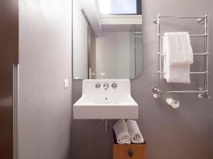 a bathroom with a sink and a mirror and towels at Casa Levante in Syracuse