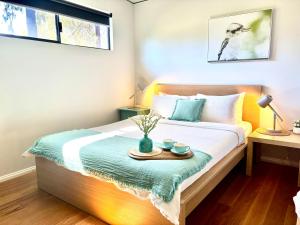 a bedroom with a bed with a tray on it at Panda's Patch Dunsborough in Dunsborough