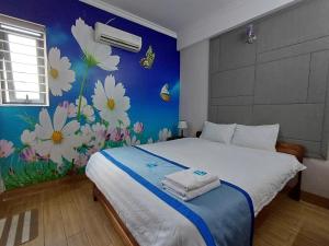 a bedroom with a bed with flowers on the wall at Hotel Lê My in Can Tho