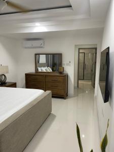 Un dormitorio con una cama y un espejo grande. en Sun Shine Luxury Villas 3 Bedroom Ocho Rios, en Ocho Ríos