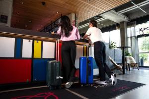 ユトレヒトにあるMoxy Utrechtの荷物を持つ男女