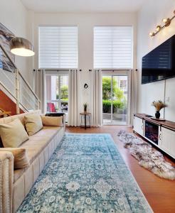 a living room with a couch and a television at Stylish Two-Story Loft with Rooftop Deck in Vancouver +55 photos