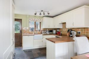 a kitchen with white cabinets and a counter top at Tom Callows - Gorgeous Rural Cottage in Epwell! in Epwell