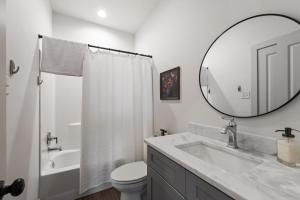 ein weißes Badezimmer mit Waschbecken und Spiegel in der Unterkunft Blues House King Bed Full Kitchen Fast WiFi in Lafayette