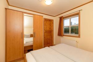 a small bedroom with two beds and a window at Ferienwohnung-Bergen in Wittenbeck
