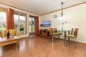 Una sala de estar con mesa y sillas y un comedor. en Ferienwohnung-Sandnes, en Wittenbeck