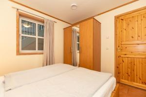 Un dormitorio con una cama blanca y una ventana. en Ferienwohnung-Sandnes, en Wittenbeck