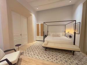 a bedroom with a white bed with a black frame at Casa Continental Hotel Boutique & Suites - Adults Only in Mérida
