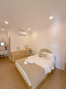 une chambre avec un grand lit avec des serviettes dessus dans l'établissement The Cozy Cottage Semporna, à Semporna