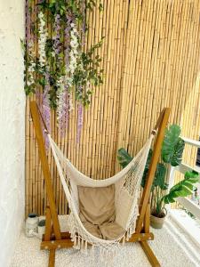 a hammock in front of a bamboo wall with flowers at The Cozy Cottage Semporna in Semporna +19 photos