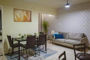 un salon avec une table et un canapé dans l'établissement Apt Mobiliado Próximo à Orla de Atalaia, à Aracaju