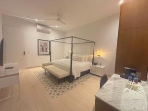 a bedroom with a large bed and a table at Casa Continental Hotel Boutique & Suites - Adults Only in Mérida