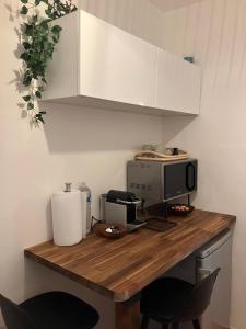 a kitchen with a wooden counter with a computer on it at Studio Cosy Illkirch in Strasbourg