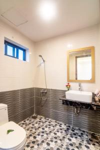 a bathroom with a toilet and a sink and a mirror at Tai Nhien Homestay in Tân Thành (1)