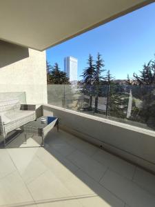 a balcony with a couch and a table and a window at Departamento nuevo full amoblado con espectacular vista a las dunas in Concón +8 photos