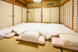 Postel nebo postele na pokoji v ubytování 岡山楽禅庵 Raku-Zen-An 岡山門田文化町の隠れ高級旅館 静寂と四季の彩りに包まれる優雅な滞在 無料駐車場有り supported by COCOSTAY