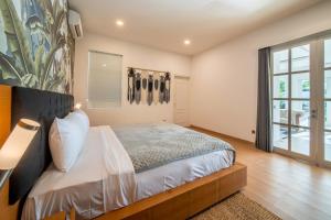 a bedroom with a bed and a large window at Villa Sound Canggu in Mengwi +25 photos