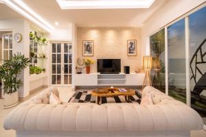 a living room with a white couch and a table at Villa Sound Canggu in Mengwi