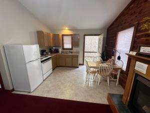 una cucina con un frigorifero bianco e un tavolo con sedie di Cedar Creek Cabins a Eureka Springs Altre 7 foto