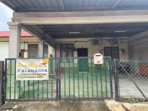 a gate with a sign in front of a building at D' Alamanda HOMESTAY CHINI in Kampong Sakai