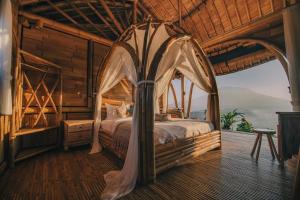a bedroom with a canopy bed in a log cabin at Laputa Bali in Sidemen