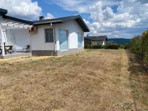 a white house with a yard with a patio at Holiday Villapark-Seaview Albena - Villa 1-2 in Rogachevo