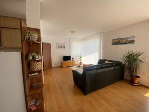 a living room with a black couch in a room at Holiday Villapark-Seaview Albena - Villa 1-2 in Rogachevo