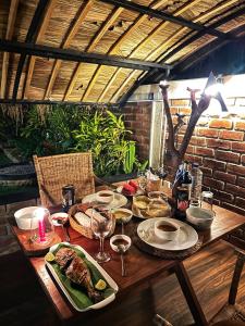 a wooden table with plates of food on it at Igabara Hobbit House in Tangalle