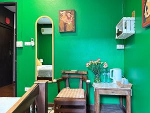 a green room with a table and a green wall at Dream Garden Villa Hotel Night Bazaar ChiangMai in Chiang Mai