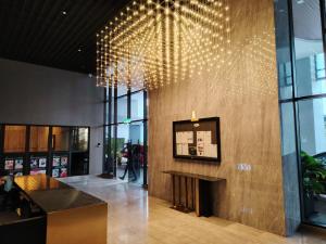 a lobby with a fireplace and lights on the wall at Trion Residence Kuala Lumpur by Luxe in Kuala Lumpur