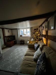 a living room with a couch and a christmas tree at Grade 2 Cottage 1 bedroom, Ludlow centre in Ludlow