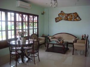 een woonkamer met een tafel en stoelen bij Keerawan House Rim Khong in Ban Wat Luang