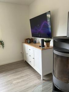 a living room with a television on a white cabinet at Ferienhäusel Allemühl in Schönbrunn