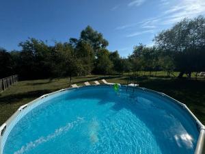 ein großer Swimmingpool mit Stühlen in einem Garten in der Unterkunft Vila ILKA in Praid